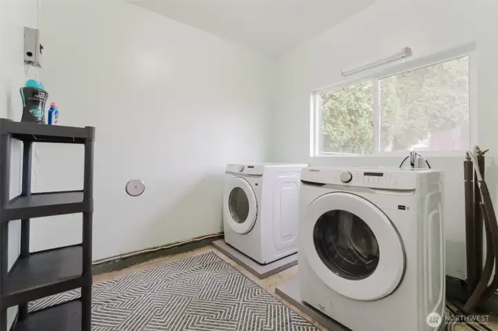 Dedicated laundry room with natural light and space for storage or shelving.