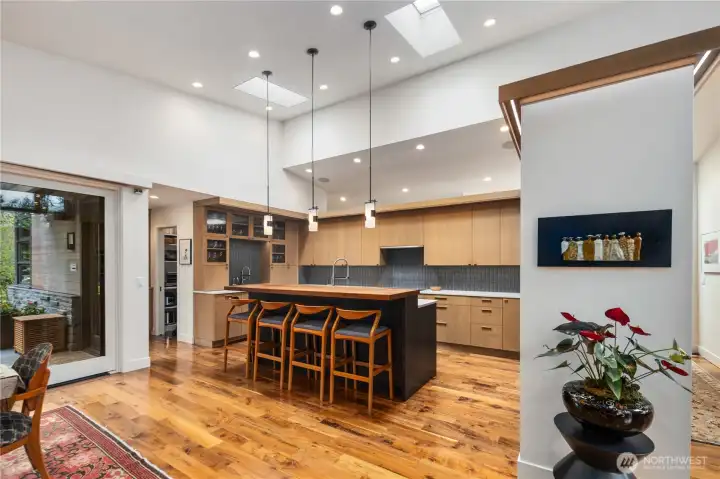 Standing in the living room, looking into the kitchen.