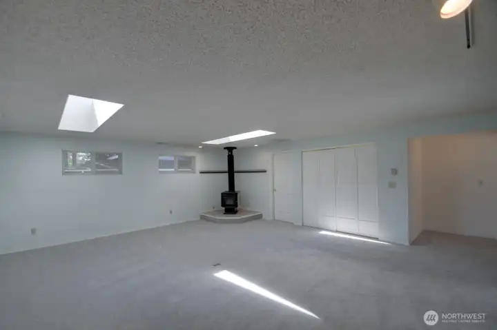 The family room is also heated by a wood-burning fireplace. Behind the bifold doors is the laundry room and the door to the left opens to a huge storage room.