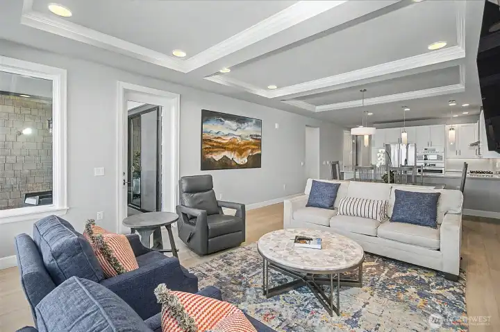 Inviting living room with clean lines, 10-foot coffered tray ceilings, and a modern, cohesive design.