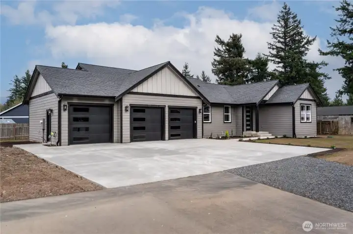 Modern farmhouse curb appeal with board and batten siding and oversized concrete driveway