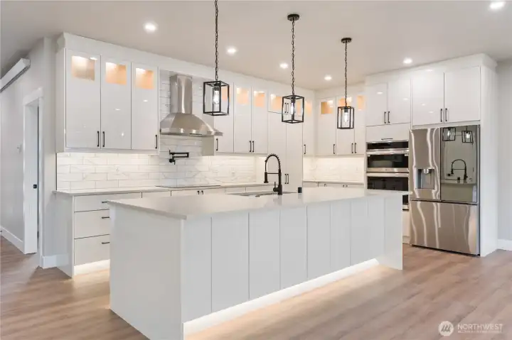 Bright open kitchen with custom cabinetry, large island, and pendant lighting
