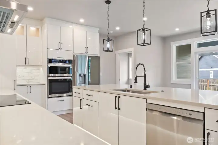 Kitchen island with undermount sink, pot filler, and range hood