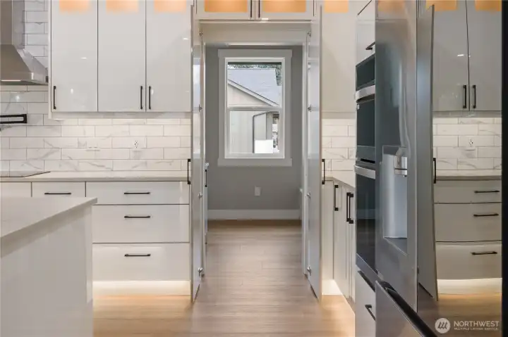 Hidden door disguised as cabinetry leading to laundry/utility room