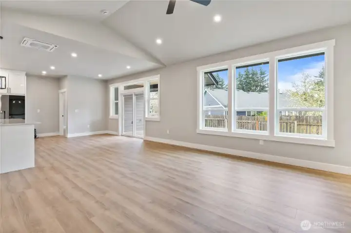 Spacious living area with vaulted ceiling and large windows