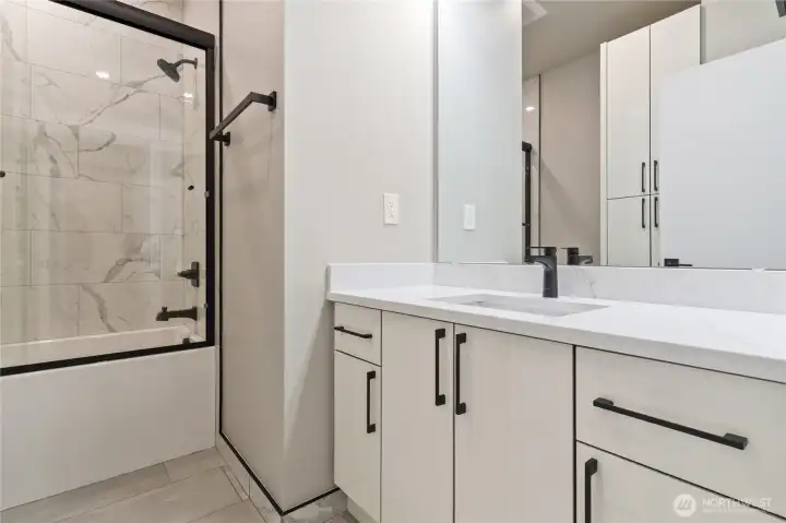 Secondary bathroom with tiled shower/tub combo and single vanity