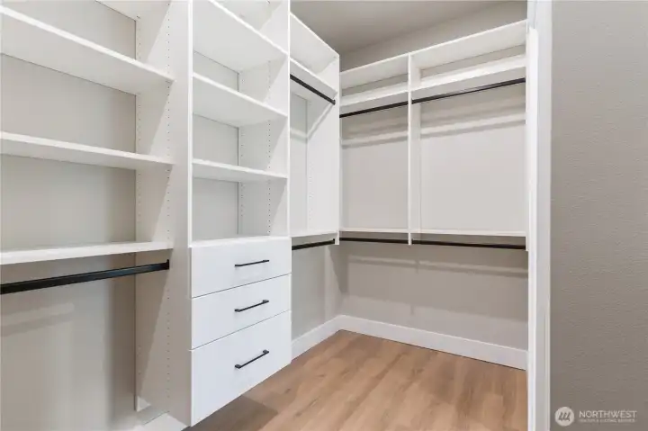 Custom closet system with built-in shelving, drawers, and hanging rods