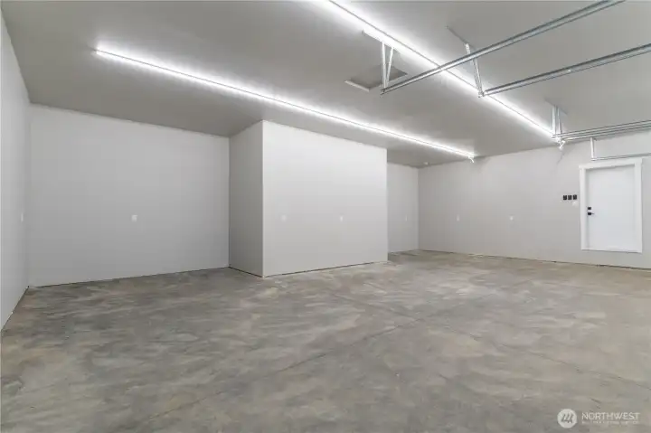 Three-car garage interior — finished with LED strip lighting and clean concrete floor