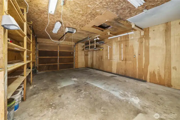 Interior of the over sized garage with 2 sets of storage shelves