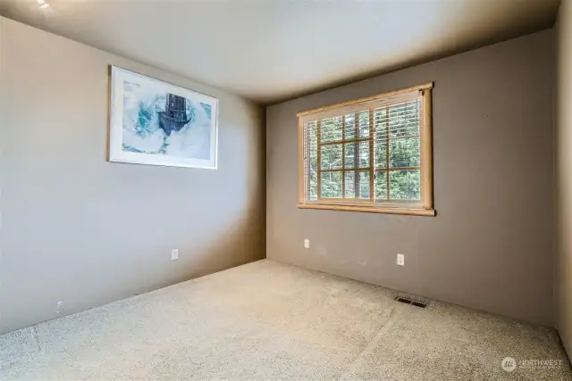 Third upstairs bedroom with wood blinds and wood-wrapped windows.
