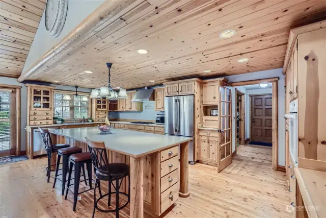 View of the front door and entry way from the gourmet kitchen. Incredible rustic chic space for all your cooking projects. That is a 4x10 foot island with loads of cabinets and drawers to store all of your appliances and gadgets.