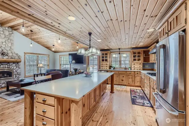 There's plenty of room to cook and gather in this kitchen family room combination. Huge 4x10 ft island with lots of pine cabinets for storage. Most have sliding organizers. Stainless appliances, including a gas cooktop, fir flooring, recessed lighting and pendants add to the ambiance.