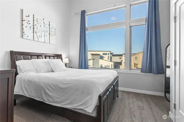 Second bedroom with huge window and partially vaulted ceiling.