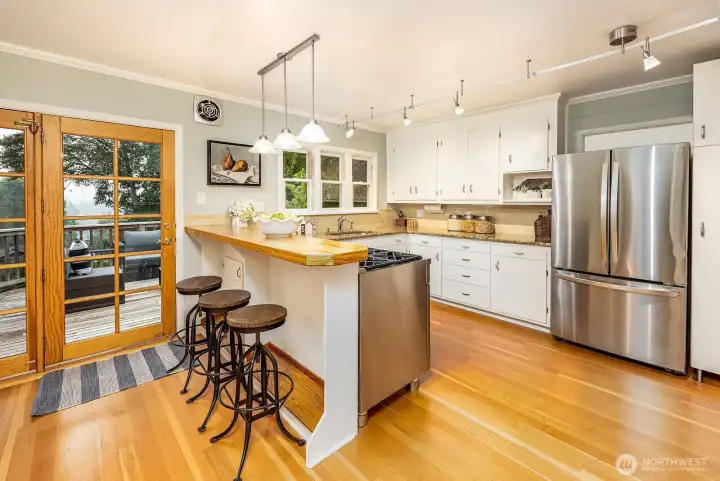 Open kitchen for ease of entertaining and access to western facing deck and access to the backyard. Newer Bosch dishwasher and gas range with electric oven for easy cooking.