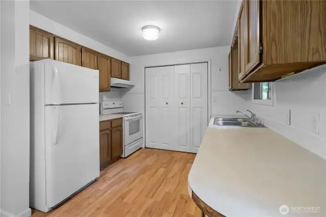 The kitchen offers plenty of counter space and storage, with easy access to the bifold doors opening to the utility closet with washer and dryer that stay.