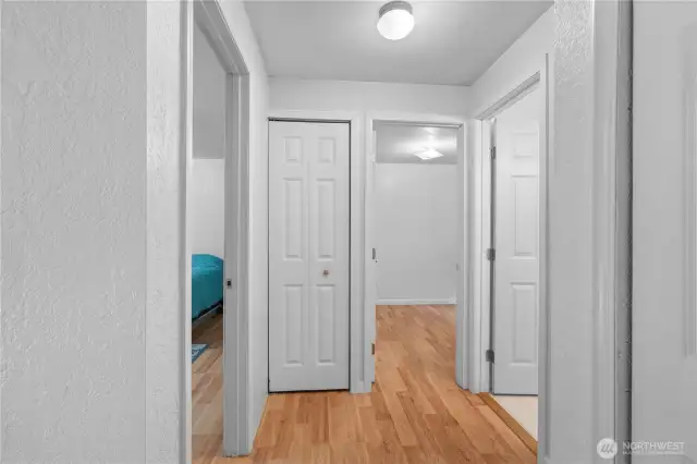 A wide hallway leads to the bathroom and the bedrooms.