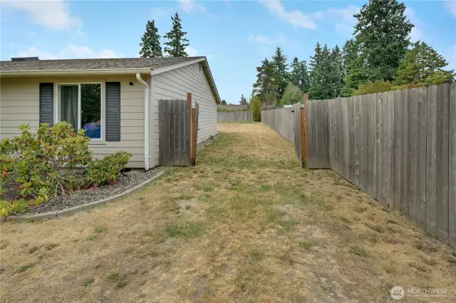 The gated access into the back yard. In the corner in the background is where underground power is installed should you wish to build a shop or garage.