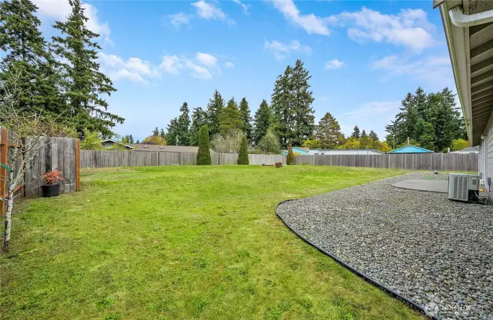 The back yard is spacious and mostly flat. The heat efficient pump is on the right, offering both efficient heating and cooling.  The awesome back yard is perfect for play, gardening, and relaxing.