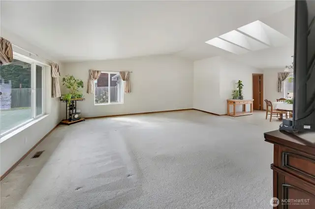 The great room without the virtual staging.  Large windows, vaulted ceiling and multiple skylights make this a bright and light space!