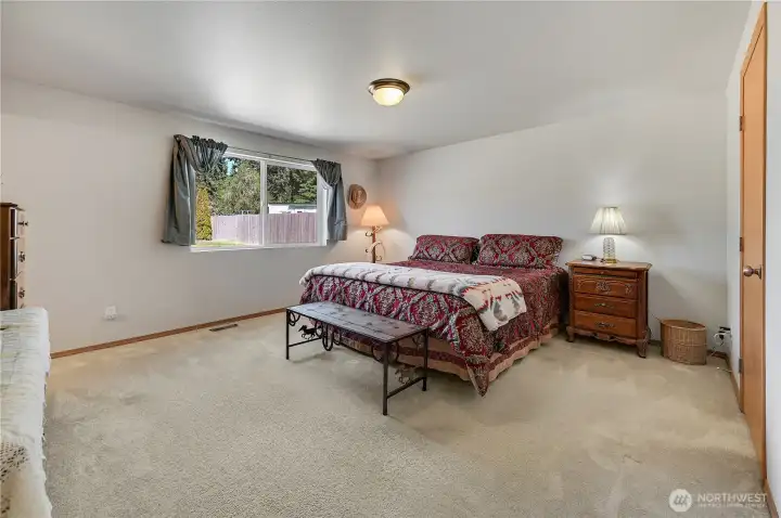 The primary ensuite, showing the King size bed, is quite spacious. The door to the right leads to a walk-in closet, plus there's a private bath as well.