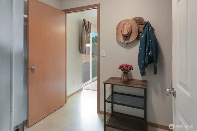 This utility/mud room off of the garage leads directly to the dining and kitchen area. The sliding door in the background leads to the spacious, fenced back yard.