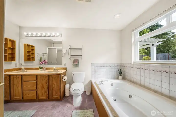 Enjoy soaking in the jetted tub, large window with view out to the well landscaped yard.