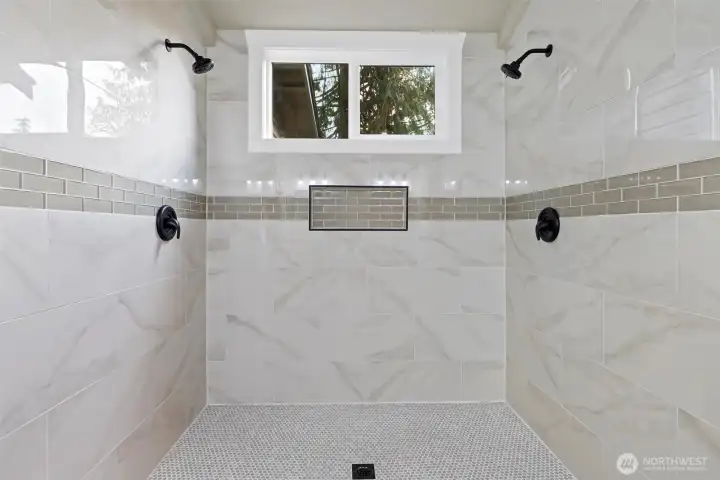 The newly remodeled primary bathroom shower with dual shower heads.