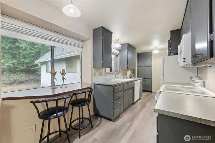 This timeless built-in bar at the backyard window will become the favorite breakfast, snack, and visiting spot in the house! Roman shades offer softness and grace to a very functional and convenient space.