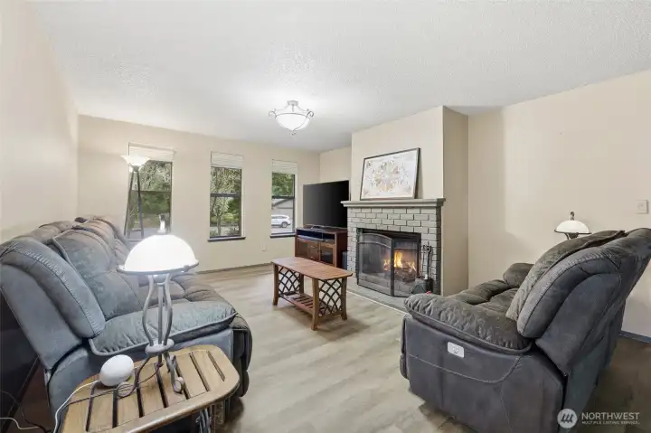 The wood-burning fireplace is a beautiful and inviting focal point in this freshly-painted, comfortable family foom.