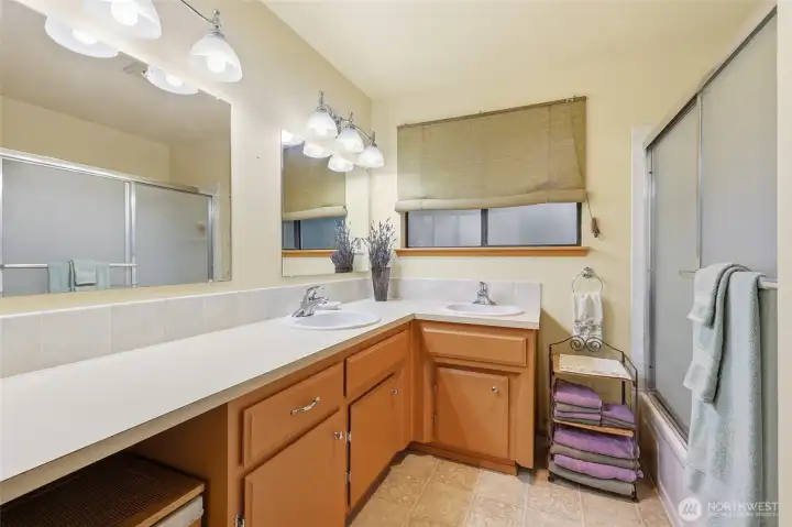 The hall bath offer double sinks, lots of counter space, glass-door shower/tub combo, and privacy glass.