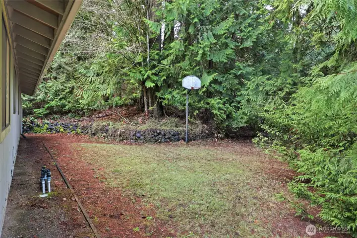 On the right side of the home is a wide, level area, ideal for a sports pad.