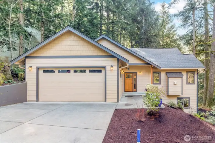Welcoming front exterior with attached two-car garage and clean, low-maintenance landscaping Welcoming front exterior with attached two-car garage and clean, low-maintenance landscaping