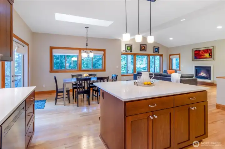 Dining area open to kitchen and living room with skylight above Dining area open to kitchen and living room with skylight above