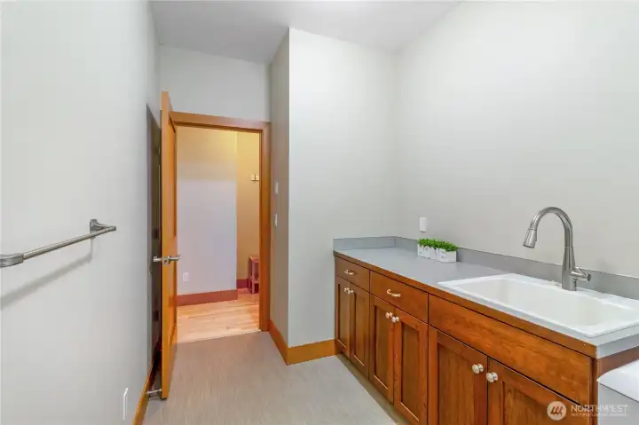 Laundry room with storage cabinets and utility sink