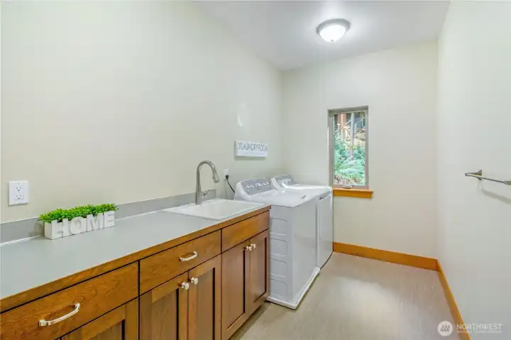 Additional laundry area view with workspace and storage