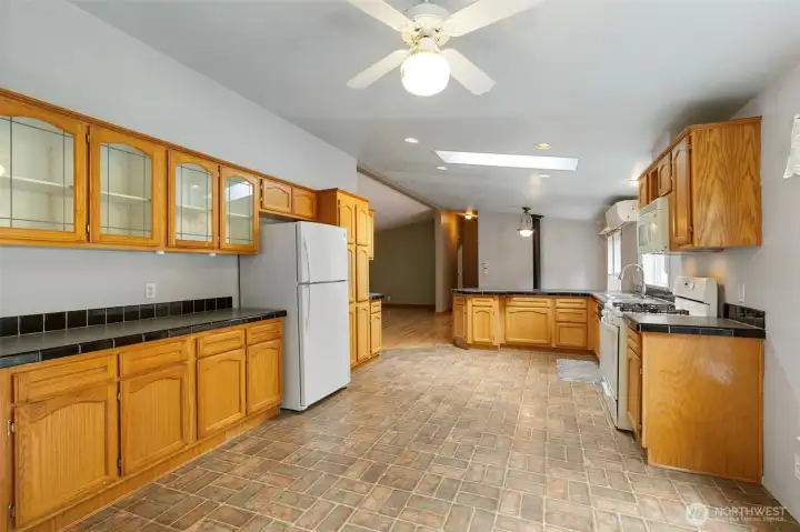 Looking from the laundry room/back entrance through the kitchen- there is clearly plenty of cabinet space and room to move.