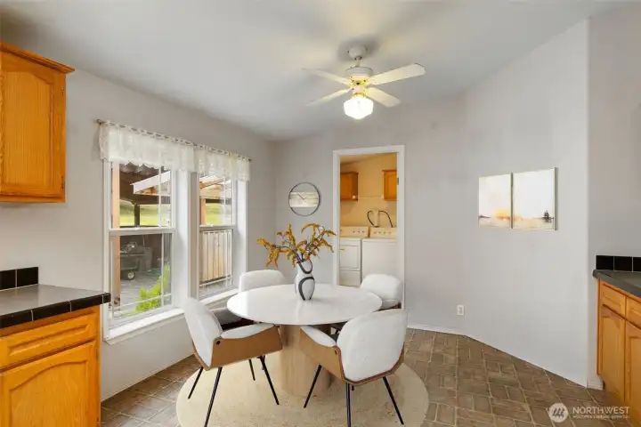 A virtually staged photo of the breakfast nook/dining area beside the laundry/mudroom back door.