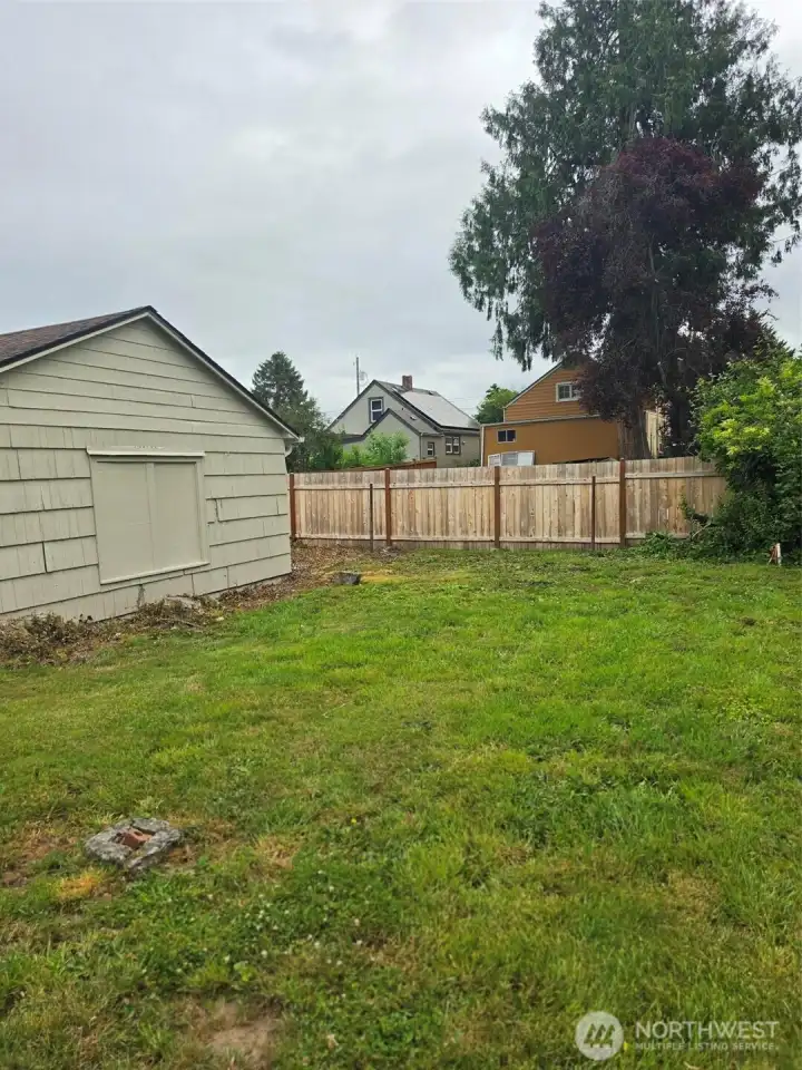 Side yare and side of garage with storage area behind.