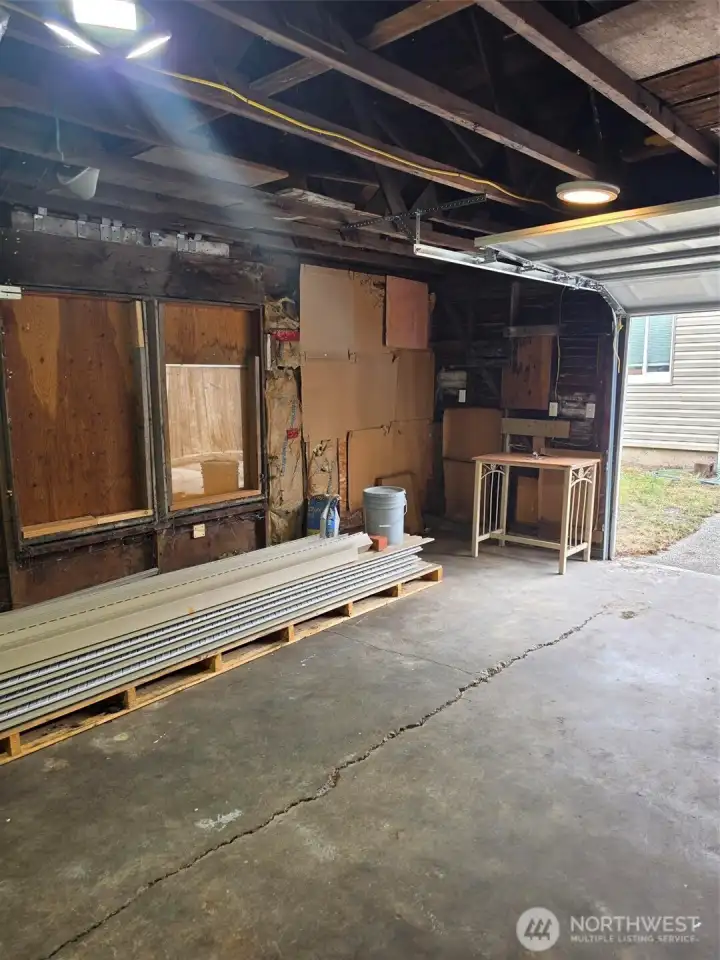 Garage with door up looking at rear of home.