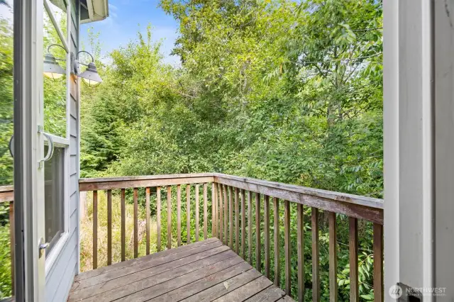 The deck off the primary suite is very private and looks out to a greenbelt with a stream running through it.