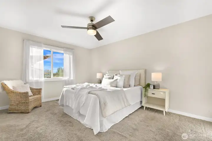 Spacious primary bedroom with large open windows for natural light.