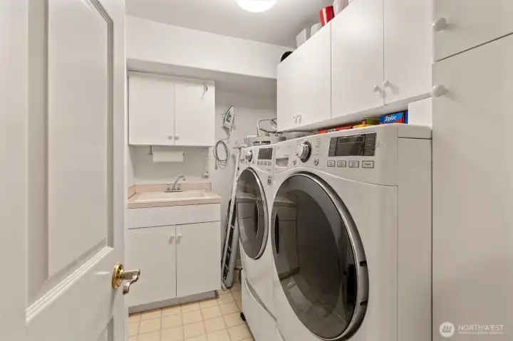 The laundry room includes a wash sink and front-load washer and dryer, making chores convenient and efficient. Newer water heater too!