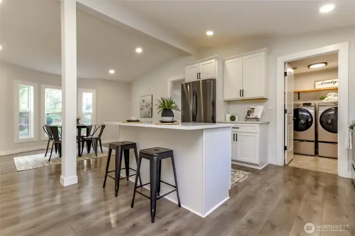 Kitchen facing the utility room. There are large storage cabinets behind the utility door great for additional pantry space. Back door to the right of washer and dryer onto covered back porch.