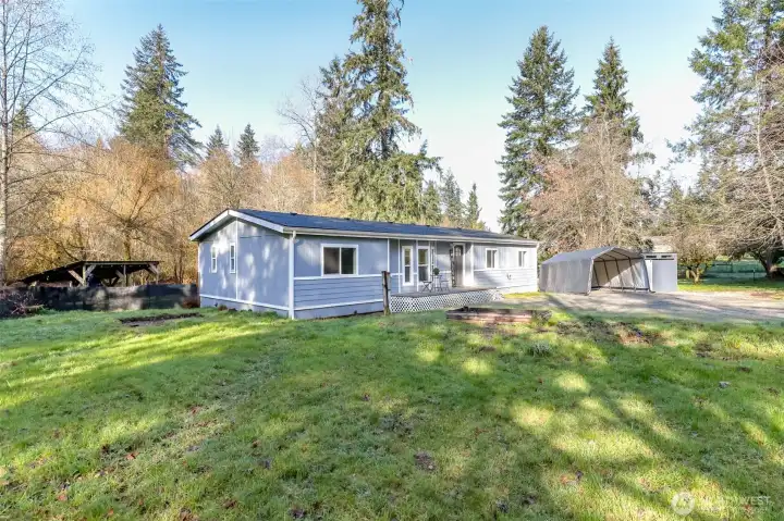 This angle of the front of the house shows the covered lean to in the backyard. Perfect for storing dry firewood for backyard firepit area.