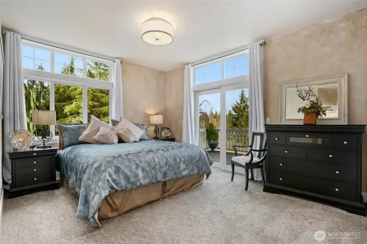 Spacious primary bedroom with ensuite bath, walk-in closet and sliders off to deck.