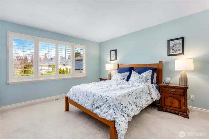Primary bedroom with plantation shutters.
