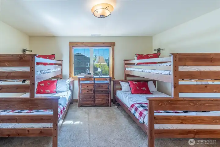 Spacious bunkroom featuring two full beds and two twin beds, perfect for guests of all ages.