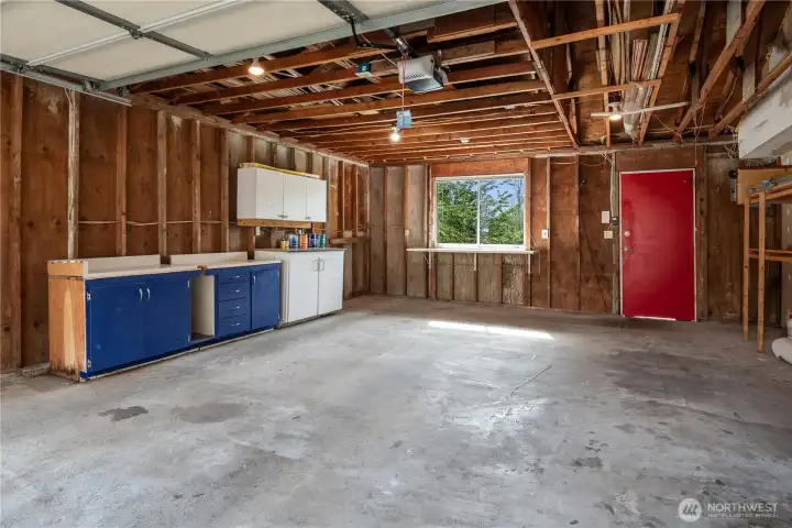This 480sf 2 car garage features an automatic door plus 2 man doors (one on the left not seen). The red door leads to the back deck and kitchen door.