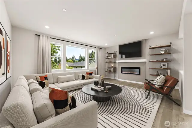 Great room with fireplace, and large windows for natural light. Photo is of actual home virtually staged.