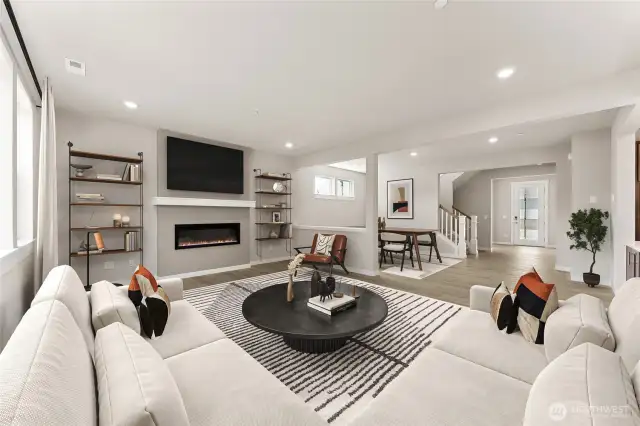 Open concept, great room with fireplace, formal dining area, and large windows for natural light. Photo is of actual home virtually staged.